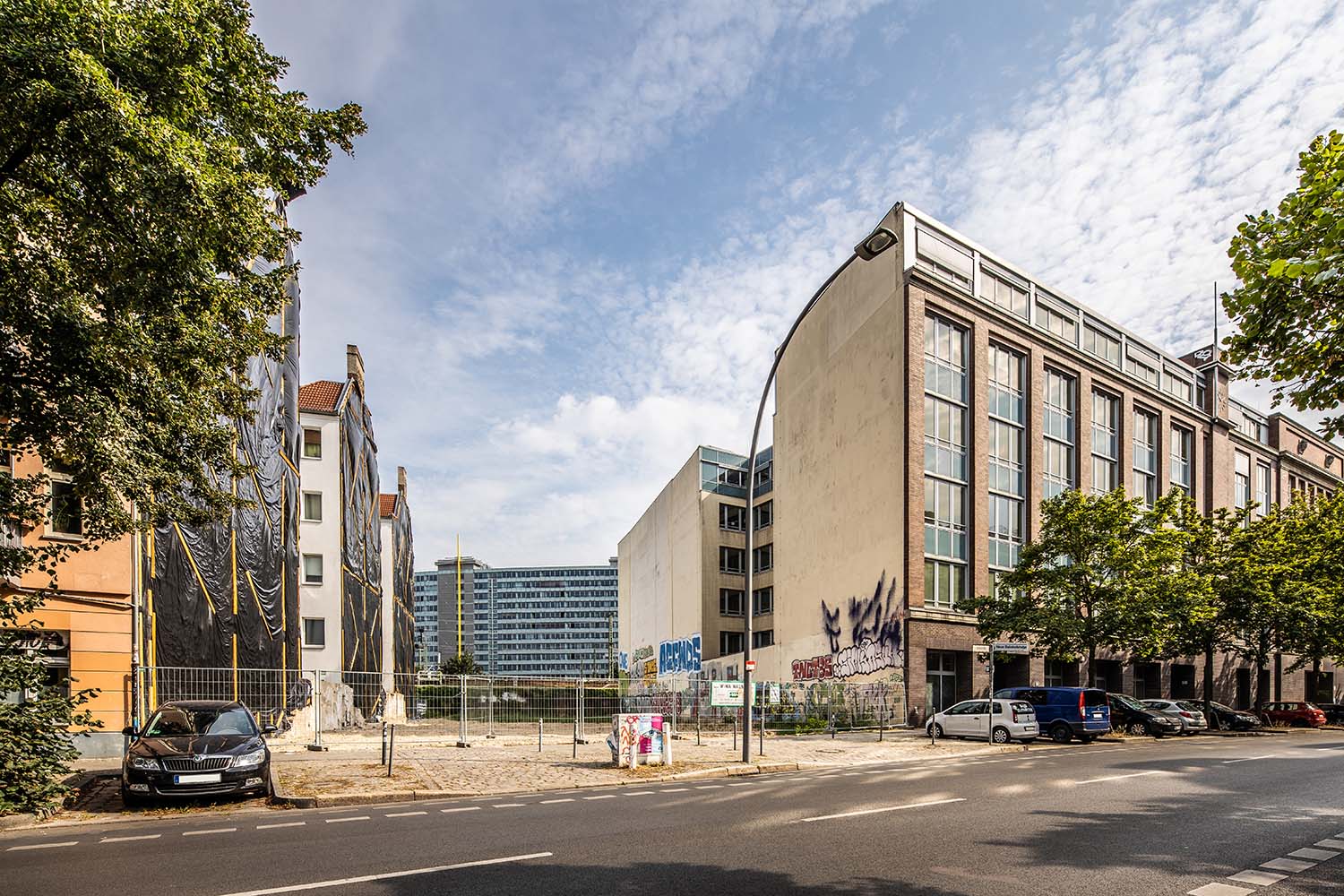Städtische Baulücke in Berlin zwischen sanierten und gewerblich genutzten Gebäuden