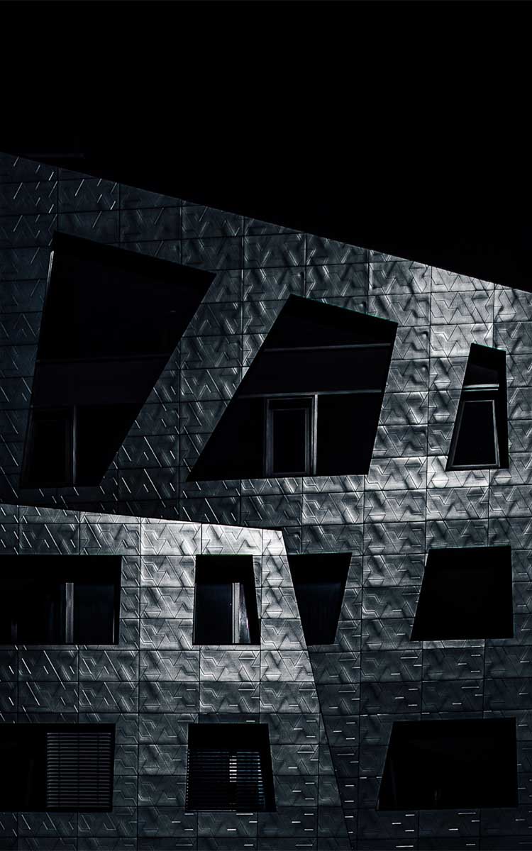 Moderne Metallfassade mit geometrischer Struktur bei Nacht, The Sapphire Berlin